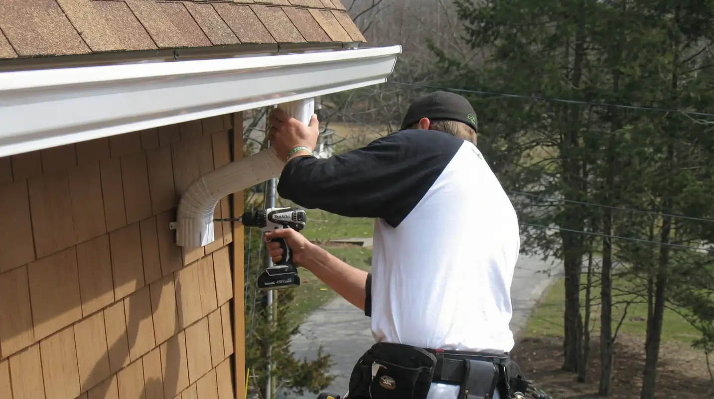 Professional contractor installing tan vinyl siding panels on a residential home exterior in Aurora, CO